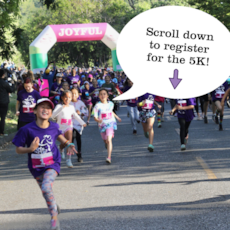 Girls on the Run participant high fives running buddy at 5K  